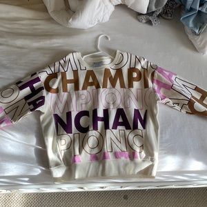 A purple, pink, and tan champion crew neck.